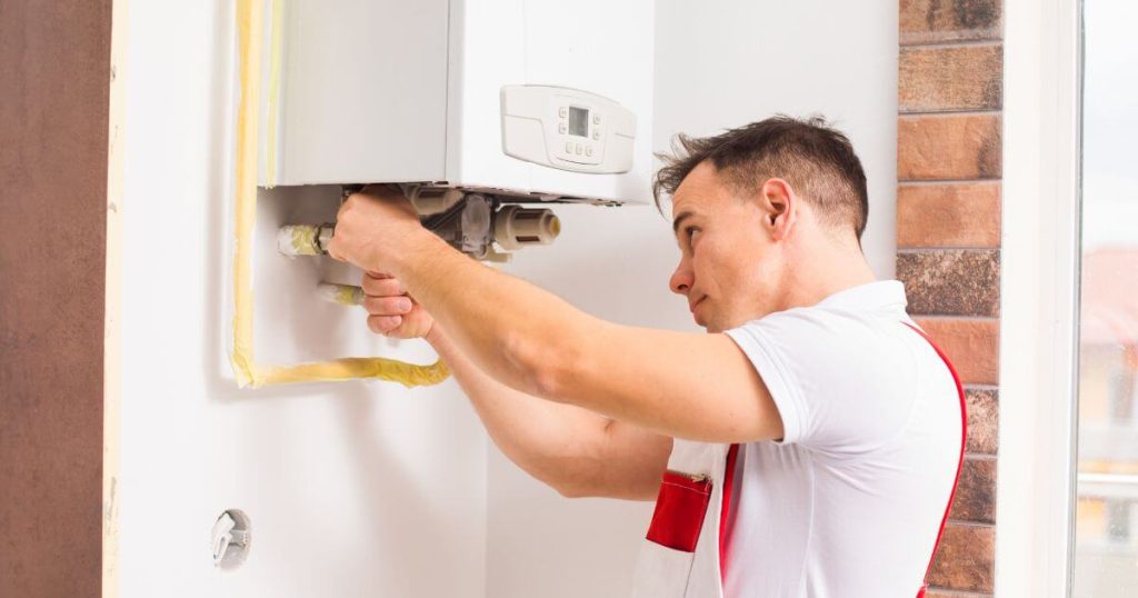 professional plumber working on a tankless water heater